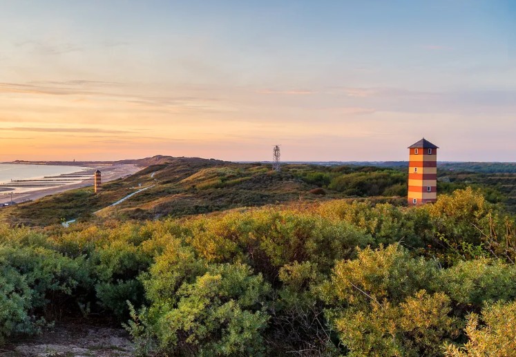 Sunset over the dunes and lighthouse at Dishoek